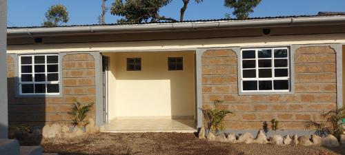 a garage with a white door and two windows at Maara Lodge Chogoria in Igoji