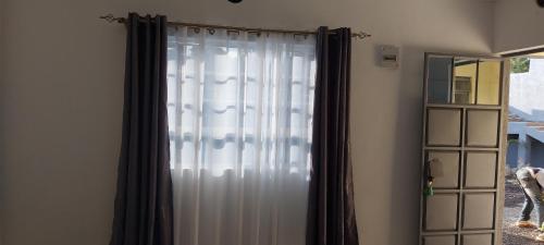 a curtain in a room next to a mirror at Maara Lodge Chogoria in Igoji
