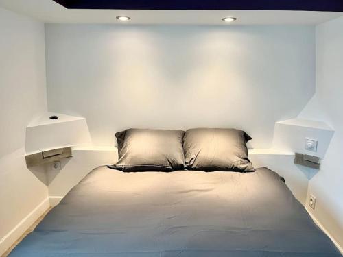 L'Antre vue - jacuzzi au château في Belberaud: سرير في غرفة بيضاء مع مصباحين