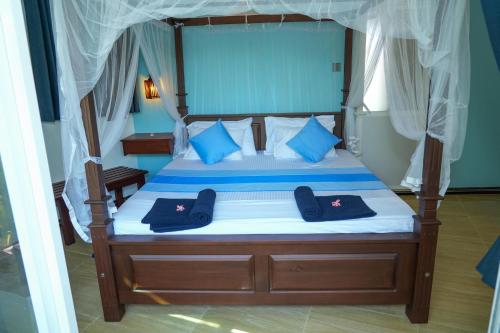 1 dormitorio con 1 cama con almohadas azules en Ocean's Eye Apartments en Unawatuna