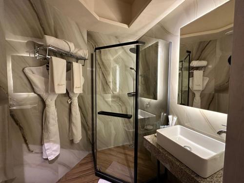 La salle de bains est pourvue d'une douche en verre et d'un lavabo. dans l'établissement Barhat Resort, à Taraz