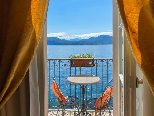 a balcony with a table and chairs and a view of the water at Hotel Cannero in Cannero Riviera