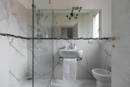 uma casa de banho com um lavatório e uma cabina de duche em vidro. em Ai piedi di San Luca - Parcheggio + 3 bagni em Bolonha