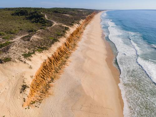 an aerial view of a beach next to the ocean at Nômade Melides Eco Lodge in Melides