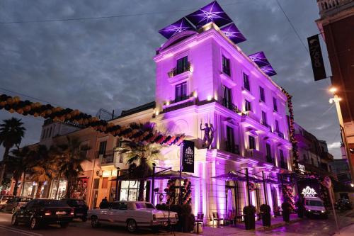 um edifício é iluminado em roxo em Envy Hotel em Durrës