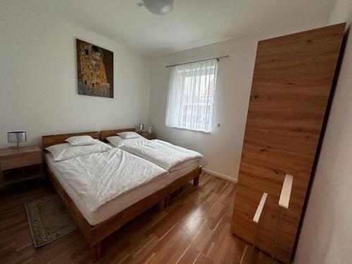 1 dormitorio con 1 cama con sábanas blancas y ventana en Sorinas Unterkunft WB7 Top 3, 
