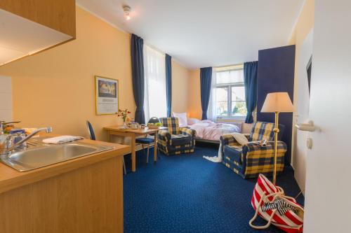 a hotel room with a sink and a bedroom at Appartementhaus Villa Norden in Kühlungsborn