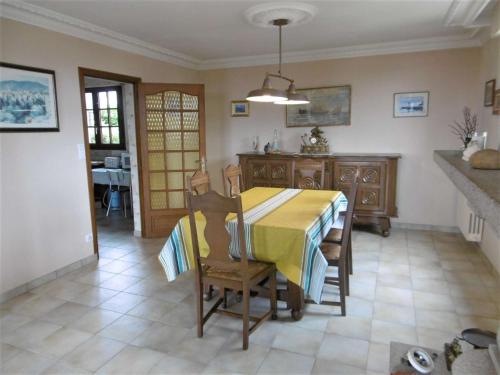 une salle à manger avec une table et des chaises jaunes dans l'établissement Maison 4 pièces 6 personnes, vue sur l'océan - Carantec, à Sarzeau