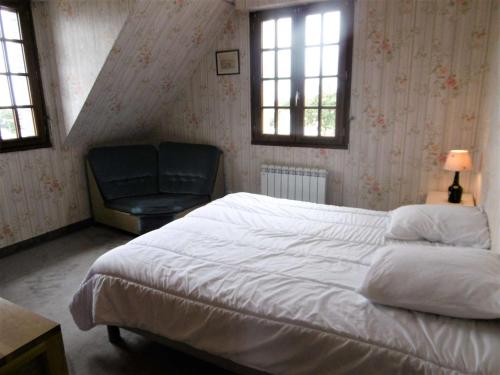 Schlafzimmer mit einem Bett, einem Stuhl und Fenstern in der Unterkunft Maison 4 pièces 6 personnes, vue sur l'océan - Carantec in Sarzeau