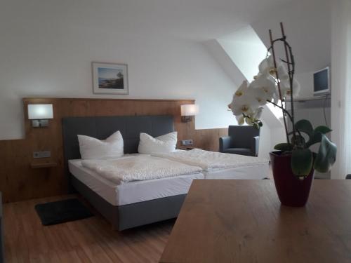 a bedroom with a bed and a vase of flowers at Gasthof Pension Grüne Au 