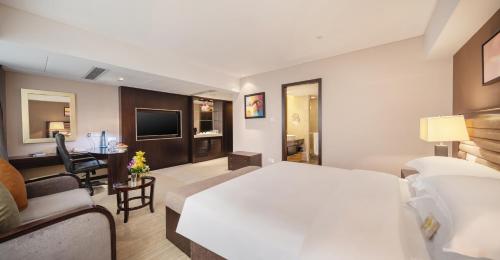 a hotel room with a bed and a living room at Shenzhen Sunshine Hotel, Luohu in Shenzhen