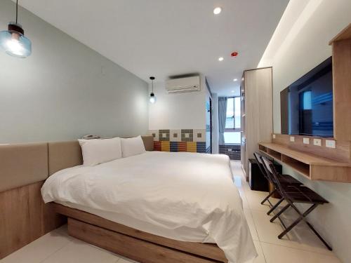 1 dormitorio con 1 cama grande y escritorio en 安平商旅Choona Hotel Anping en Anping