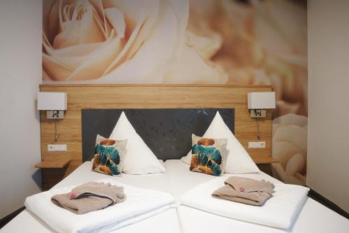 1 dormitorio con 1 cama con 2 almohadas en Outlet Hotel, en Metzingen