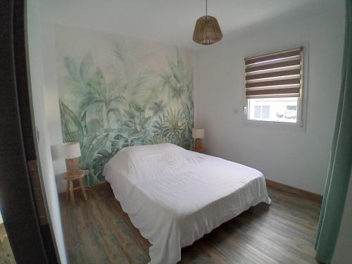 Un dormitorio con una cama blanca y una pintura en la pared en Pavillon au calme a 5mn de VESOUL, 