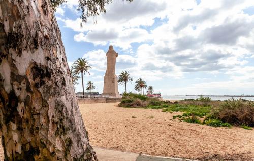 a monument on the beach with palm trees in the background at Vive Huelva MARINA WIFI 300 VFTHU01194 in Huelva
