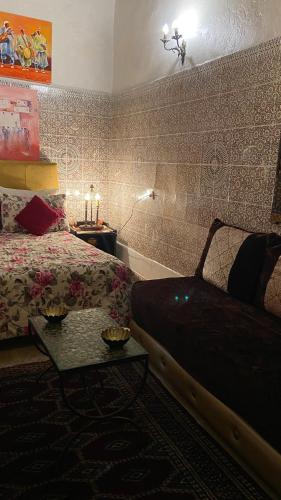 a bedroom with a bed and a table and a couch at DAR LALLA Aicha 2 in Rabat
