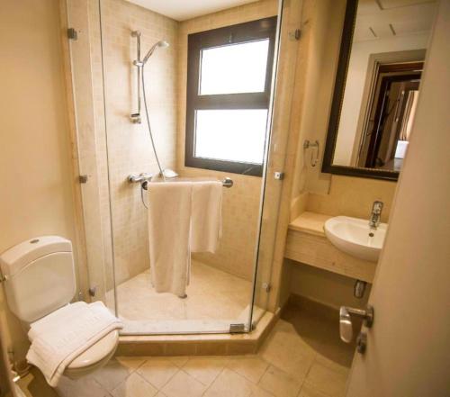 a bathroom with a shower and a toilet and a sink at Marina Residence Suites Port Ghalib in Port Ghalib