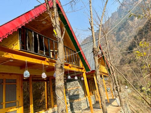 a house with a red and green roof at Sainj Riverside Cottages in Sainj