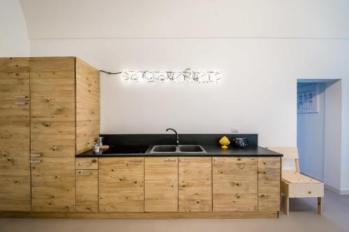 eine Küche mit einer Spüle und Holzschränken in der Unterkunft B&B Casa Ninè in Gioia del Colle