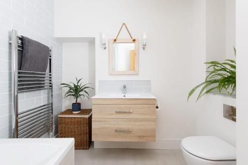 La salle de bains est pourvue d'un lavabo et d'un miroir. dans l'établissement Luxury Cottage Conversion ~ Close to Beaches, à Birdham