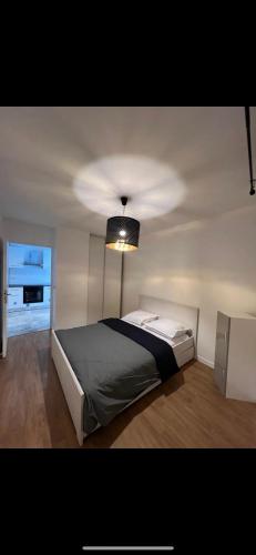 ein Schlafzimmer mit einem Bett mit einer Decke in der Unterkunft Spacieux appartement Paris/Stade De France/CDG in La Courneuve