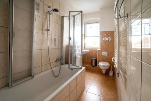 a bathroom with a shower and a tub and a toilet at Moderne Ferienwohnung in der Stadt in Forst