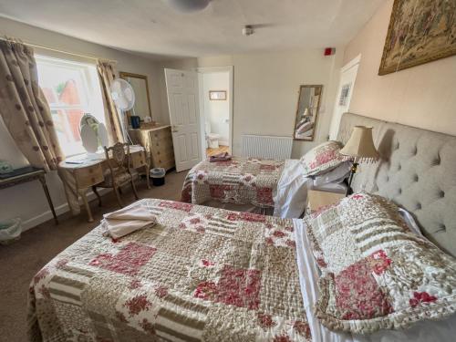 a bedroom with two beds and a table and a window at The Vintage Inn in Wellington