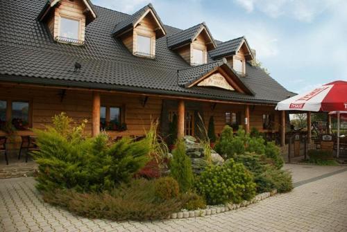 a building with a roof with a bunch of bushes at Pyszna Stajenka in Bąków