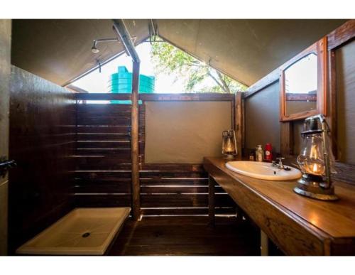 La salle de bains est pourvue d'un lavabo et d'une baignoire. dans l'établissement Mankwe Camping, à Chiro Pan