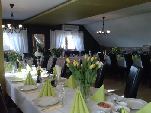 a long table with yellow flowers in a room at Pyszna Stajenka in Bąków