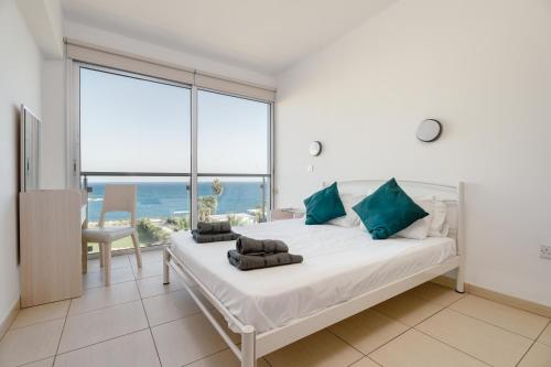 Schlafzimmer mit einem Bett und Meerblick in der Unterkunft Stunning one-bedroom apartment with sea views in Protaras