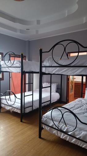 a room with three bunk beds in a room at The Garden in Thong Sala