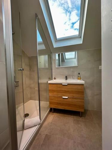 La salle de bains est pourvue d'un lavabo, d'une douche et d'une lucarne. dans l'établissement Maison Cosy, Grand Paris, à 3 minutes du métro, à Villejuif