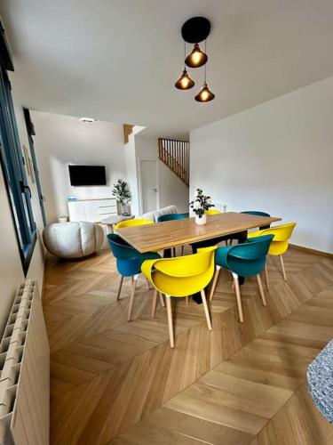une salle à manger avec une table en bois et des chaises jaunes dans l'établissement Maison Cosy, Grand Paris, à 3 minutes du métro, à Villejuif