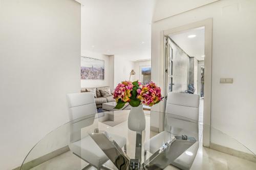 - un salon avec un vase de fleurs sur une table en verre dans l'établissement Vista Real, à Marbella
