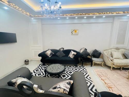 sala de estar con sofá y lámpara de araña en برج الولاء بالغشام شقة فندقية Vip, en Manshīyat as Sādāt