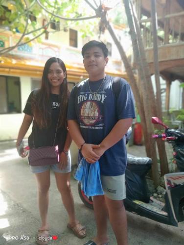 a man and a woman standing next to a motorcycle at Bambooze Hauz in Boracay