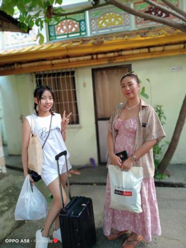 two women standing next to each other with luggage at Bambooze Hauz in Boracay