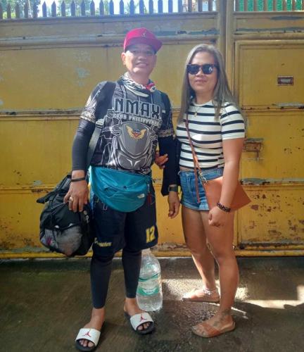 a man and a woman standing next to a yellow wall at Bambooze Hauz in Boracay