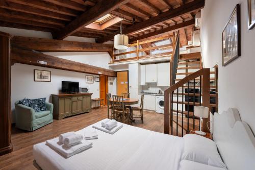 a bedroom with a white bed and a living room at Era Rental Apartments in Florence