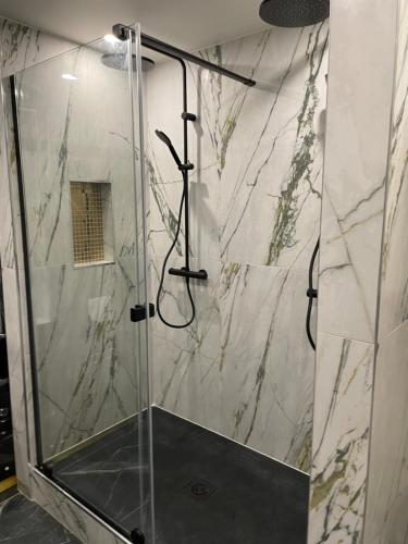 une salle de bain avec une douche avec une porte vitrée dans l'établissement Proche Paris - Style Bali 350 m gare Mantes, à Mantes-la-Jolie