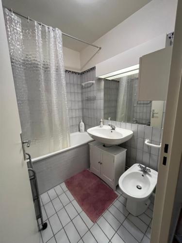 a bathroom with a sink and a tub and a toilet at Paris 15 jardin parking privé à côté de la Porte de Versailles in Paris