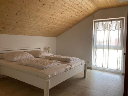 a bed in a room with a large window at Villa Kleine Welle in Trent