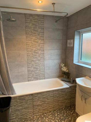 a bathroom with a tub and a sink at Belle View cottage in Bewdley