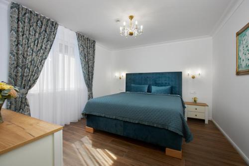 a bedroom with a blue bed and a chandelier at Rustyfox in Remetské Hámre