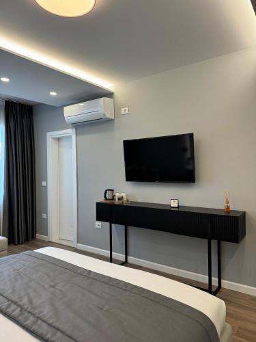 a bedroom with a flat screen tv on the wall at L’Hotel Tirana in Tirana