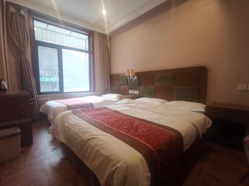 Llit o llits en una habitació de Beijing Huiqing Garden Bussiness Hotel