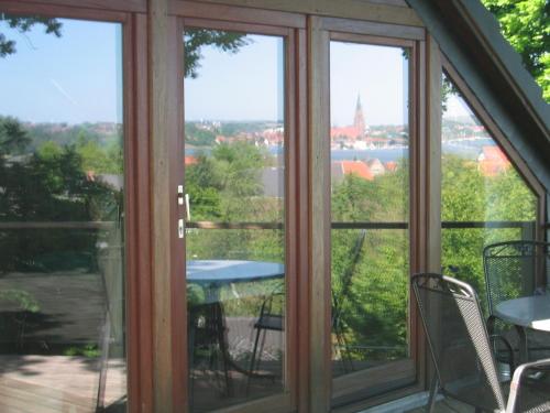 a screened in porch with a view of the water at FeWoFahrdorf in Fahrdorf