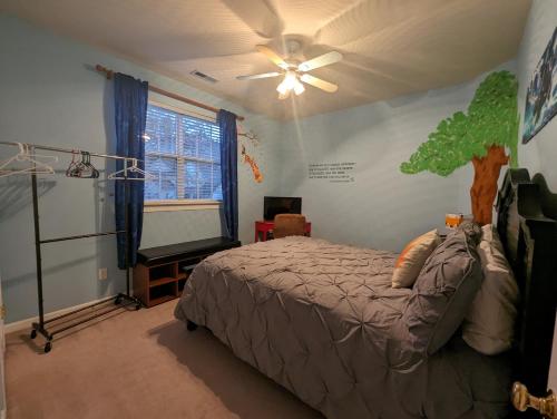 a bedroom with a bed and a ceiling fan at Chateau Relaxo Concord in Huntersville