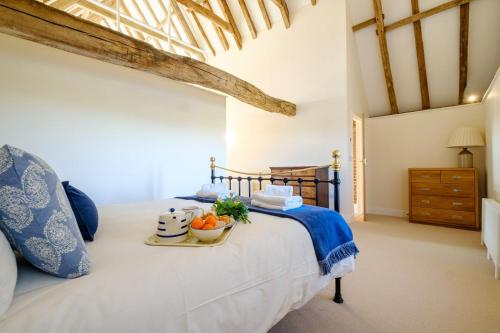 a bedroom with a bed with a tray of fruit on it at Upper Barn in Ufford